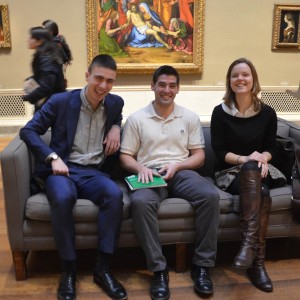 Student Curators Lucas, Charles and Kate seated before Solario’s Lamentation