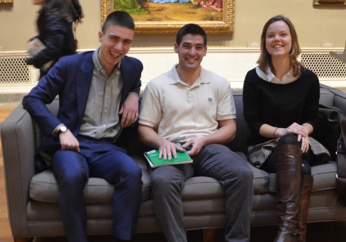 Student Curators Lucas, Charles and Kate seated before Solario’s Lamentation